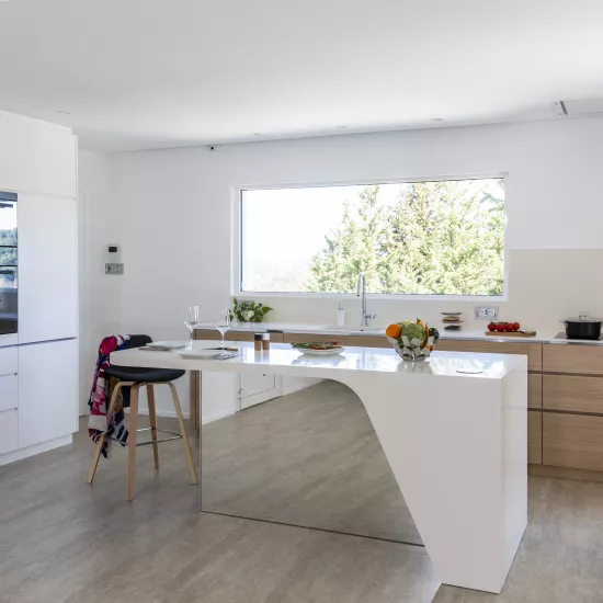 A contemporary, light-filled HIMACS kitchen with a mountain view