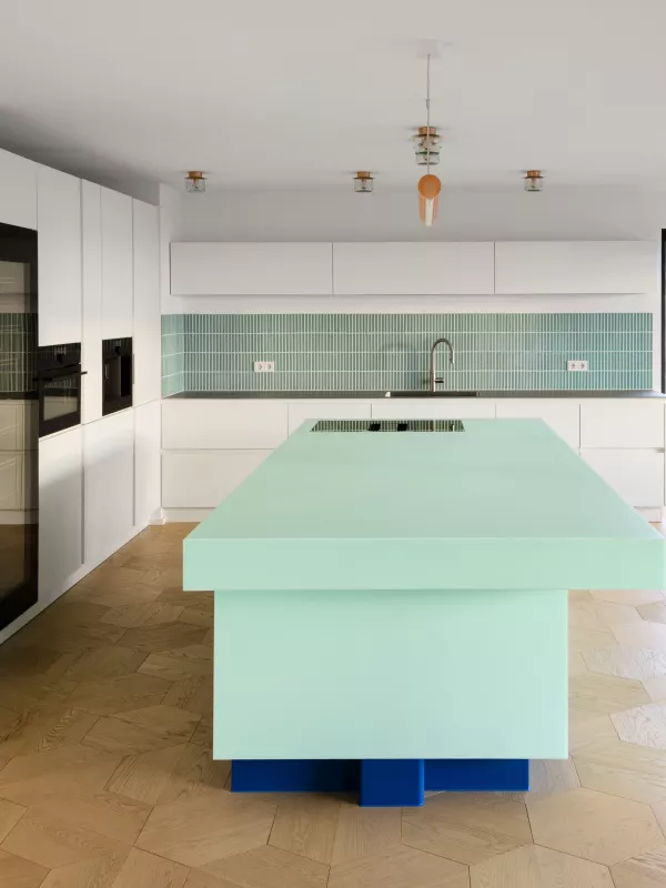 Juego de contrastes en una llamativa isla de cocina diseñada en el tono HIMACS Emerald