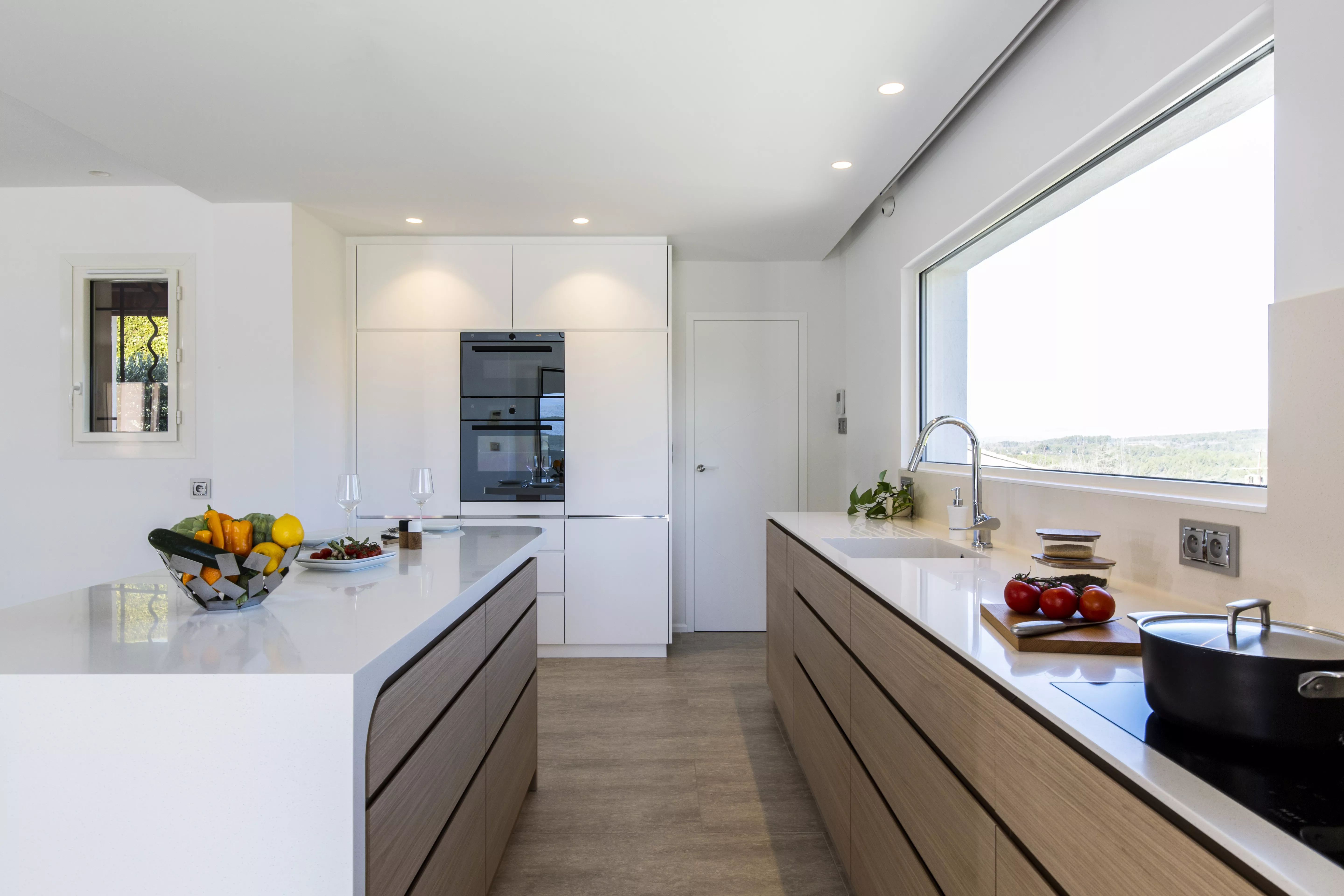 A contemporary, light-filled HIMACS kitchen with a mountain view