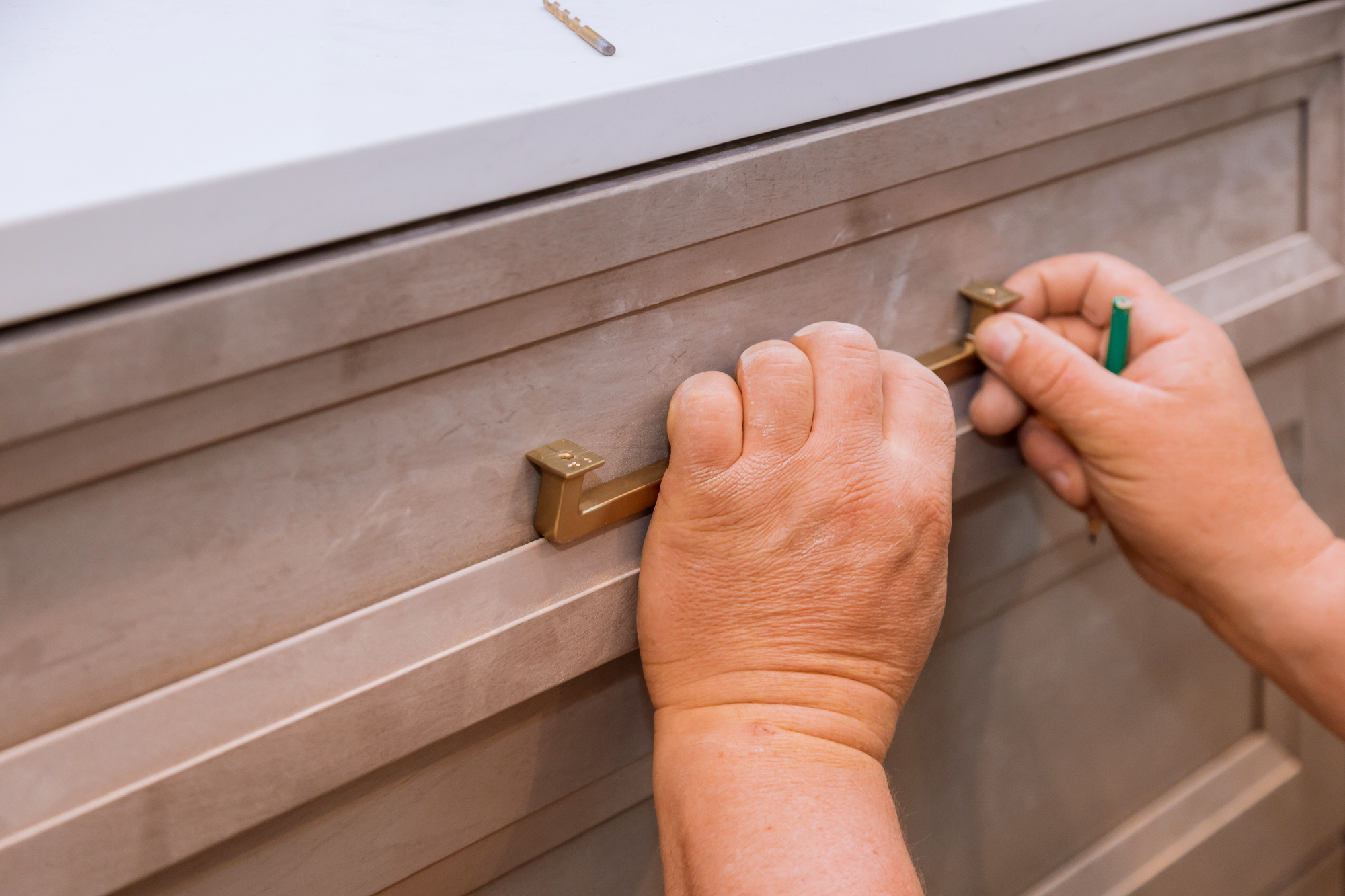 Measure and accurately mark the location of the drawer handle. Then, drill pilot holes in the appropriate locations to attach the handle.