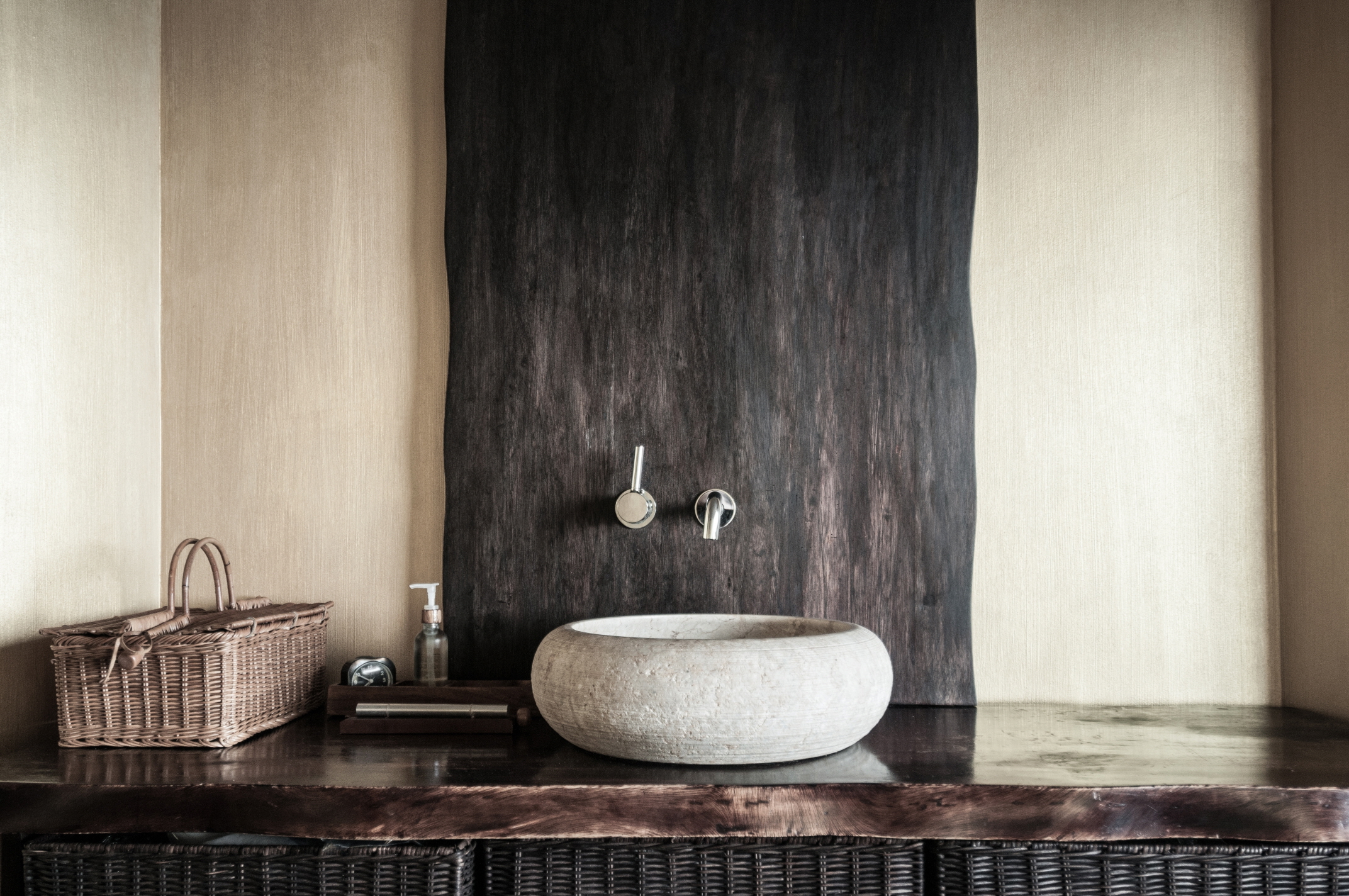 Complete a neutral bathroom with wood vanities, marble countertops, and other complementary materials.