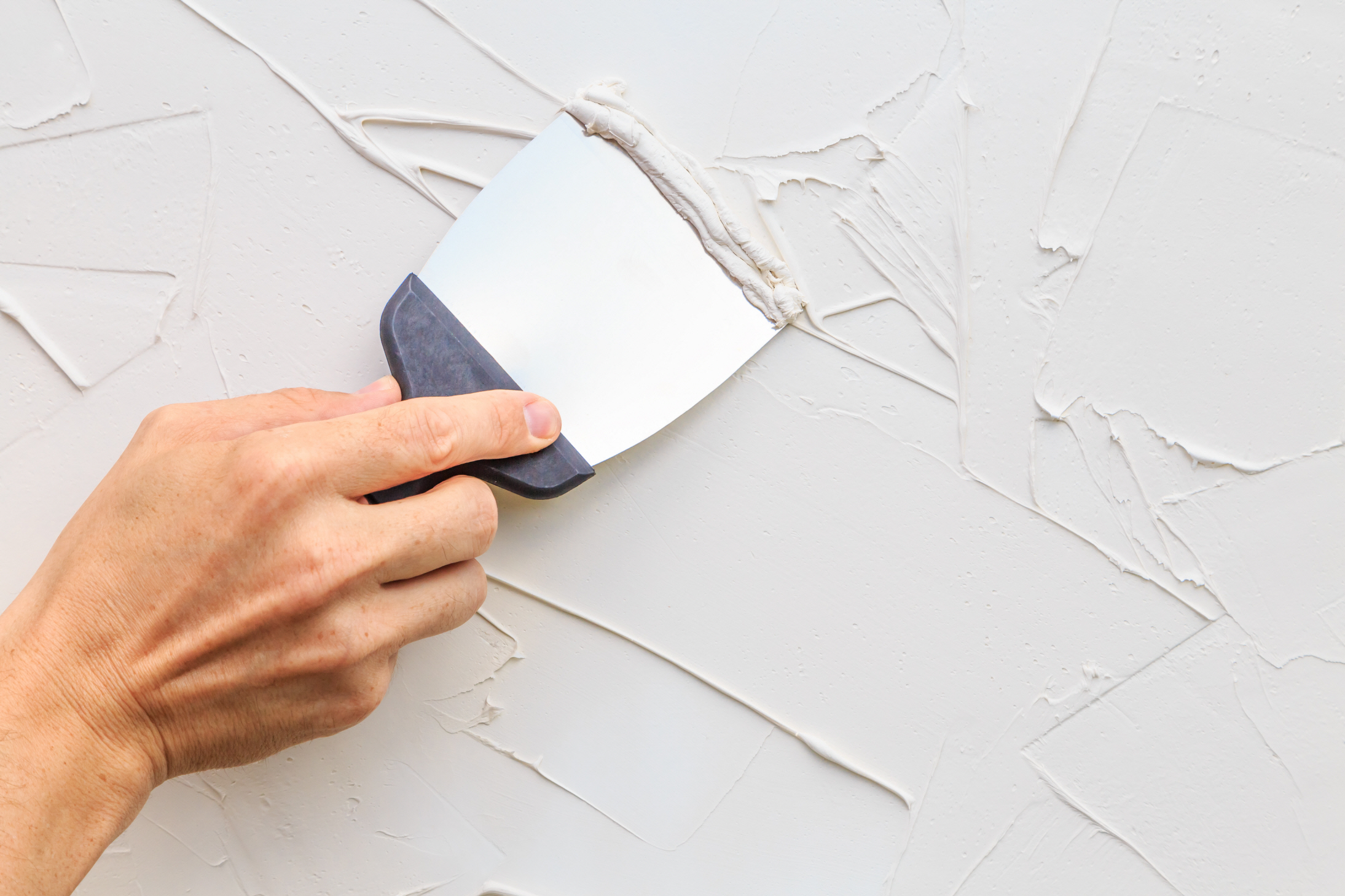 Once you've removed the bathroom vanity, it's important to use a putty knife to repair any wall damage.