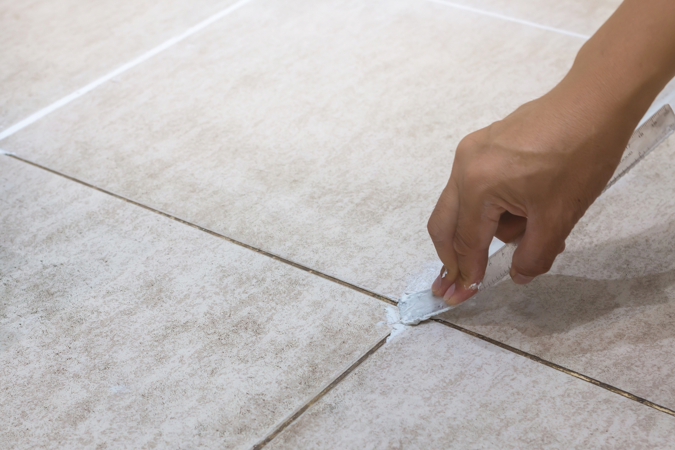 Fill the grout between the tiles for a smooth finish, creating a fresh, beautiful bathroom floor.