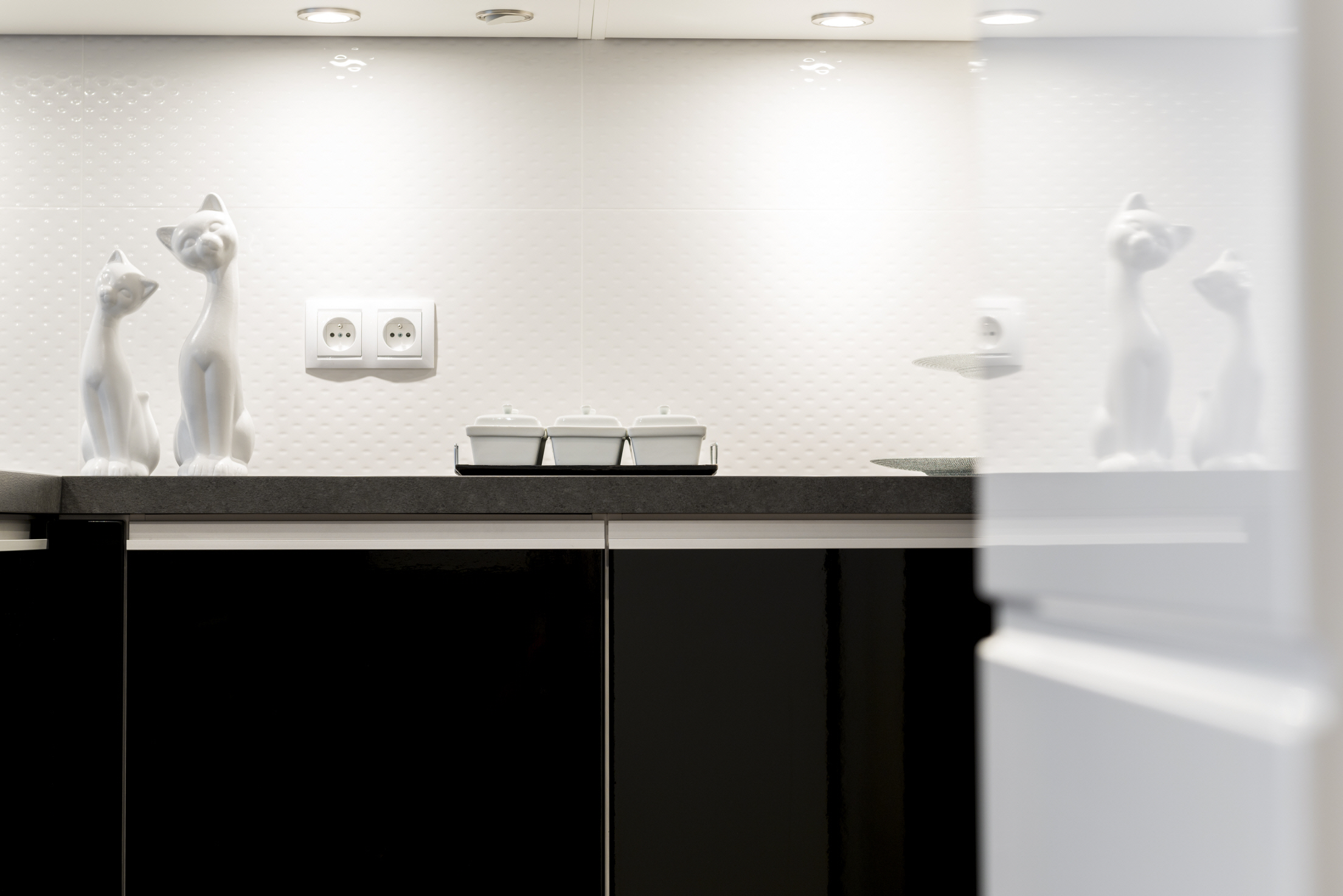 Add visual depth to your kitchen space with glossy black cabinets.