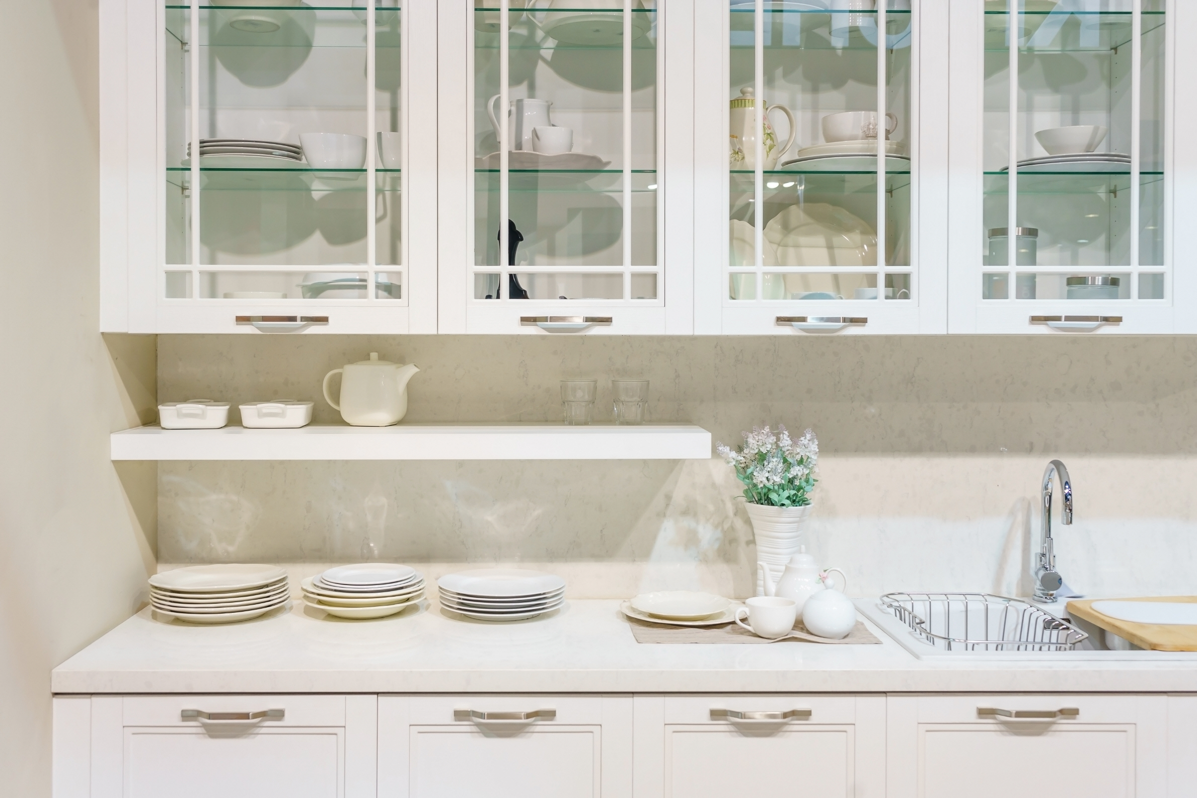 Clear glass cabinets allow light to flow freely throughout the room, making the kitchen appear larger.