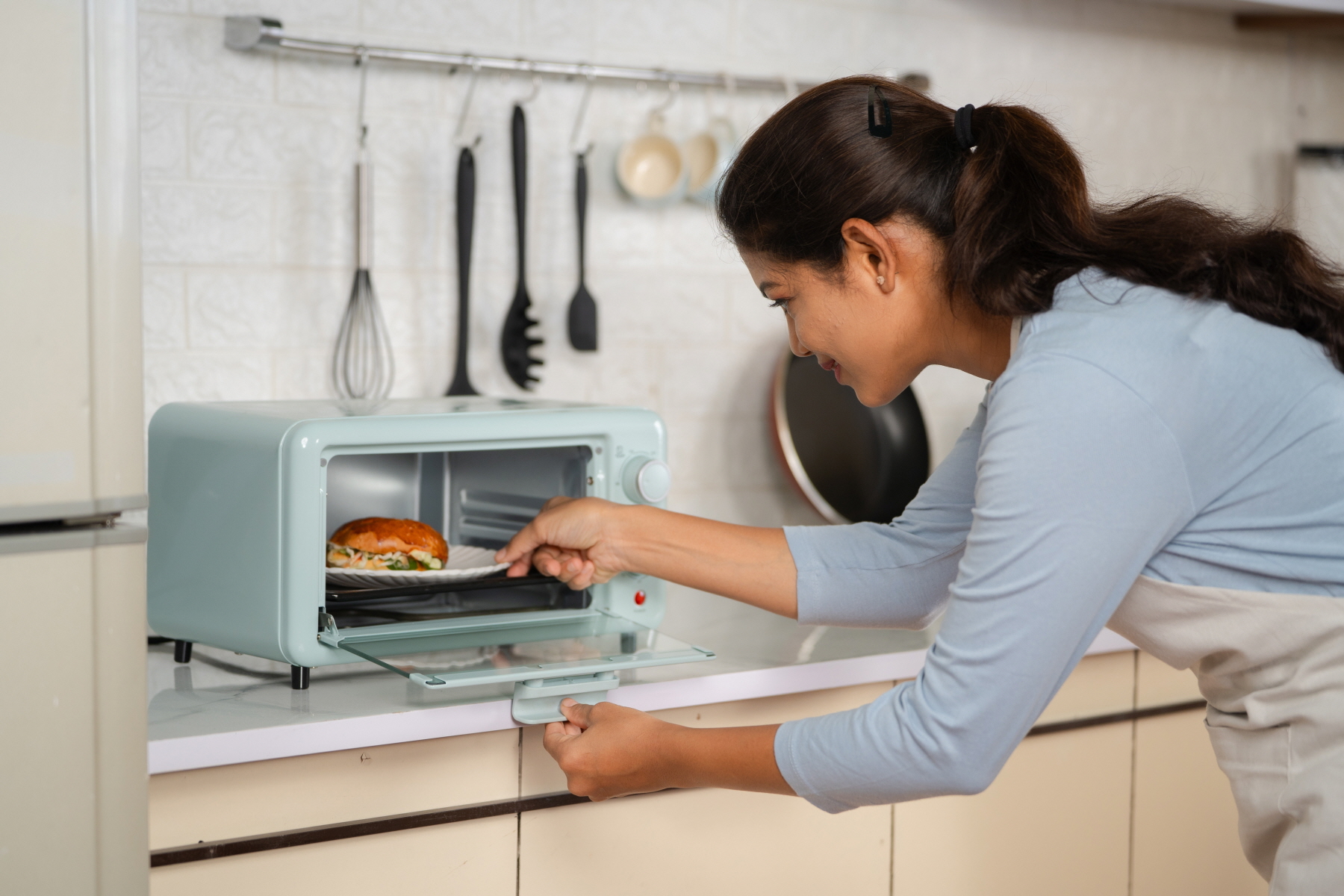 If you rarely use your oven, opt for a small toaster oven to free up additional space in your kitchen.