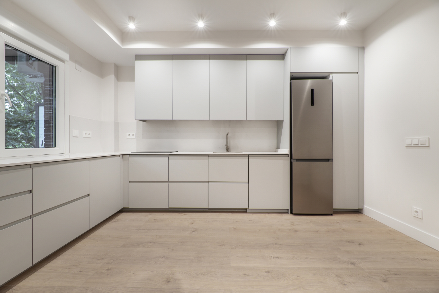 An L-shaped kitchen layout is a design that uses two adjacent walls to form an “L” shape.