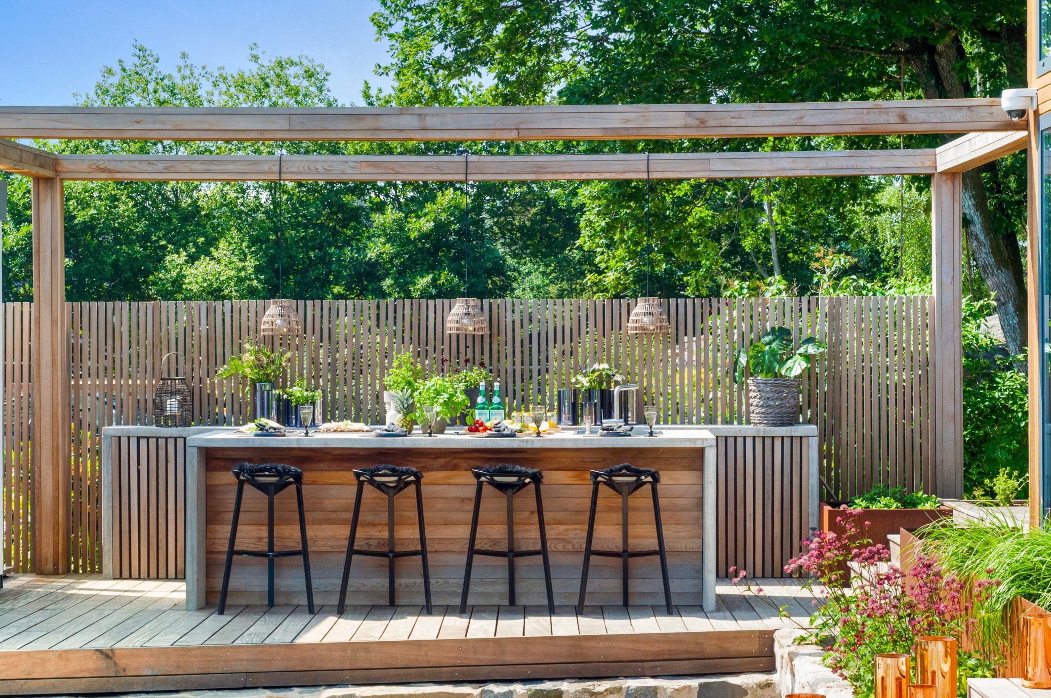 The best way to make your outdoor kitchen the center of entertainment is to add a bar.